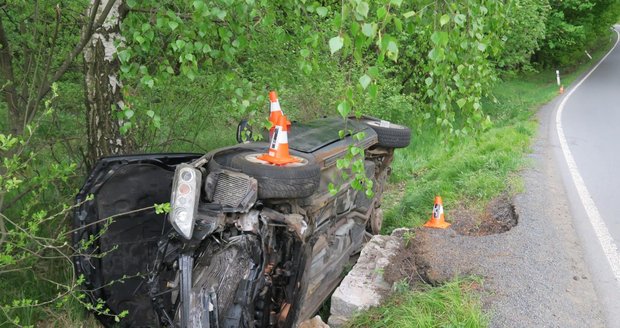 Mazda po nehodě skončila na boku v příkopu.