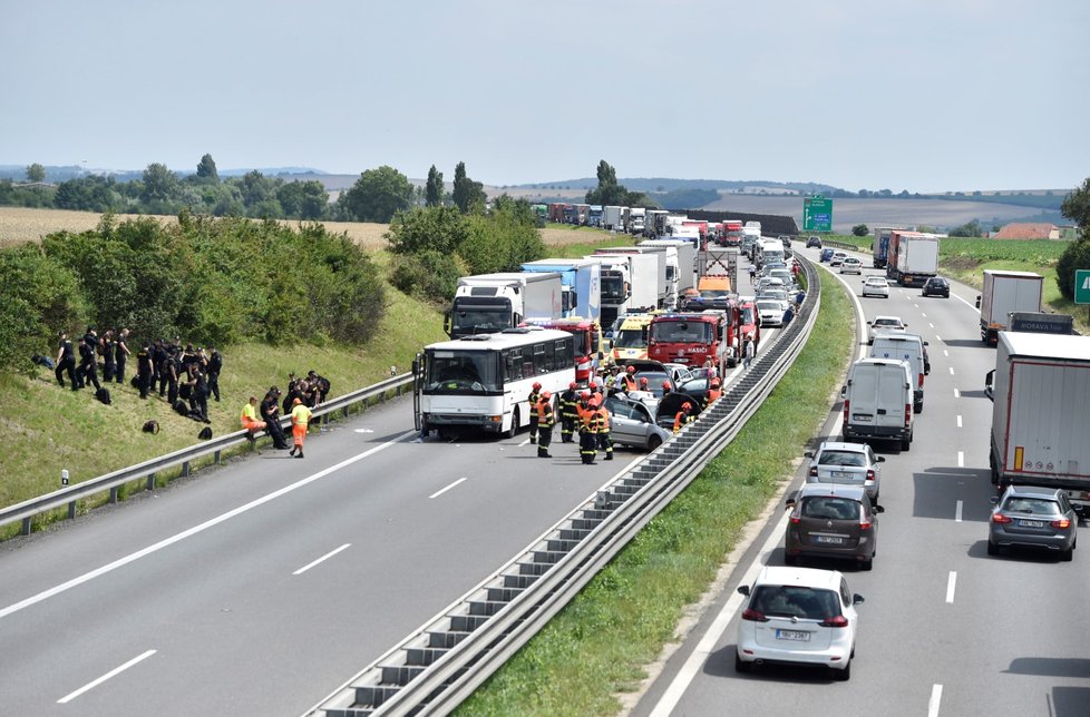 Provoz na dálnici D1 zastavily  na 208. kilometru u Holubic ve směru na Brno dvě nehody, dva lidé utrpěli zranění. Srazily se dva osobní vozy a vůz s autobusem, který převážel poicisty.