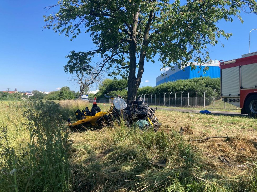 Audi R8 zůstalo po nehodě omotané kolem stromu a trosky rozházené všude kolem.