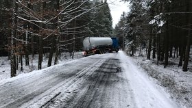 Kamion u Hostomic projel dva zákazy a skončil mimo cestu: Ledovka bránila i jeho vyproštění