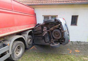 Uvolněný kamion napasoval auto pana Pavlíčka na domek.