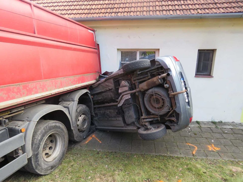 Uvolněný kamion napasoval auto pana Pavlíčka na domek.
