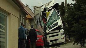 Za volantem tohoto kamionu najel český řidič do protijedoucí dodávky a pak rodiného domu. Nehodu odnesl zraněním