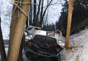 Auto obrácené na střechu uvízlo mezi stromy, řidič z něj vylezl nezraněný.