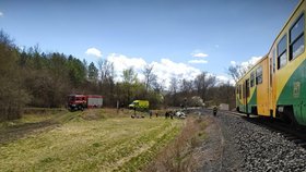 Vážná dopravní nehoda na Lounsku: Auto po srážce s vlakem skončilo na střeše.