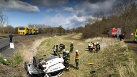 Vážná dopravní nehoda na Lounsku: Auto po srážce s vlakem skončilo na střeše.