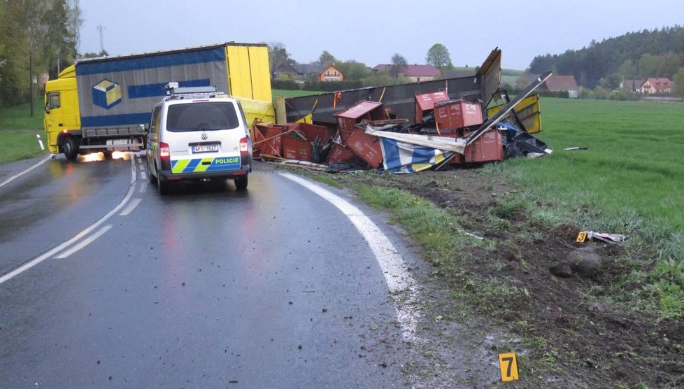 Řidička náklaďáku dostala smyk, převrátila přívěs a zatarasila silnici.