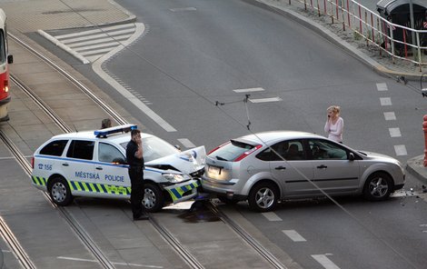 Strážník a řidička po děsivé srážce z mobilů přivolávají pomoc.