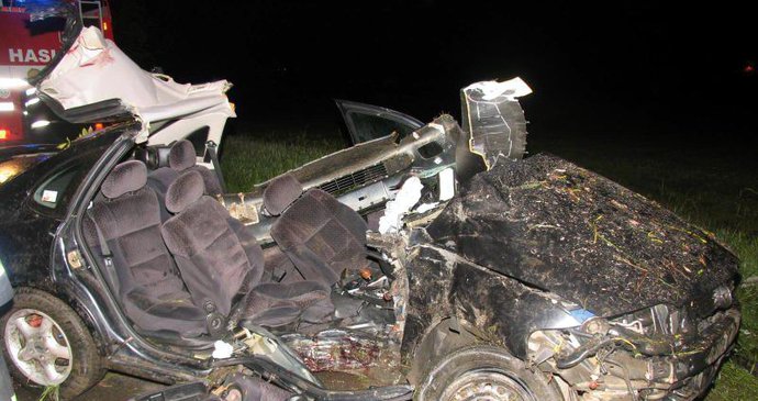Ve zničeném autě zemřel mladík, těžce zraněného řidiče vystříhali z vraku hasiči.