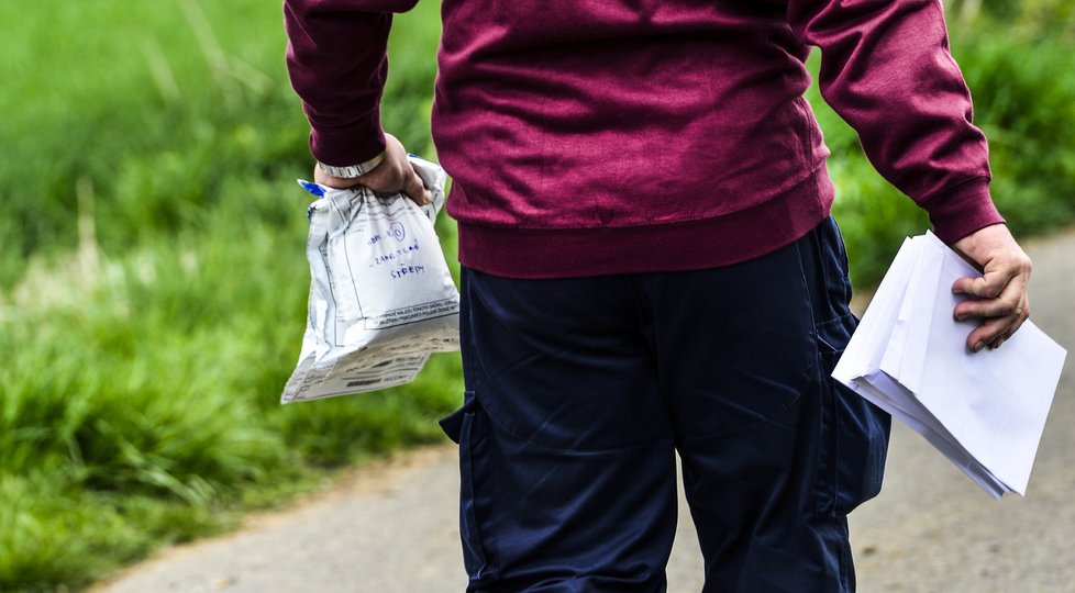 Kriminalista odnáší důkazy, v jednom ze sáčků jsou zametené střepy z místa činu