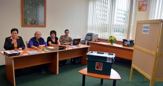 Čtyři členové volební komise volebního okrsku Vojenský újezd Březina si dlouhou chvíli ve volební místnosti v dědických kasárnách krátili povídáním.