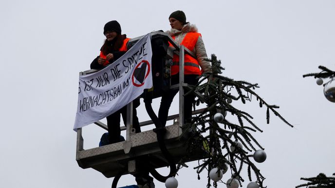 Aktivisté z ekologického hnutí Poslední generace (Letzte Generation) v centru Berlína u Braniborské brány uřízli špičku vánočního stromu. (21.12.2022)