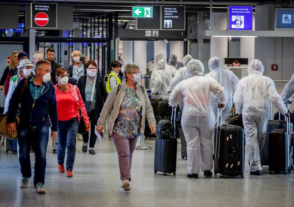 Posádka South African Airways na letišti v německém Frankfurtu míjí další cestující (18. 4. 2020)