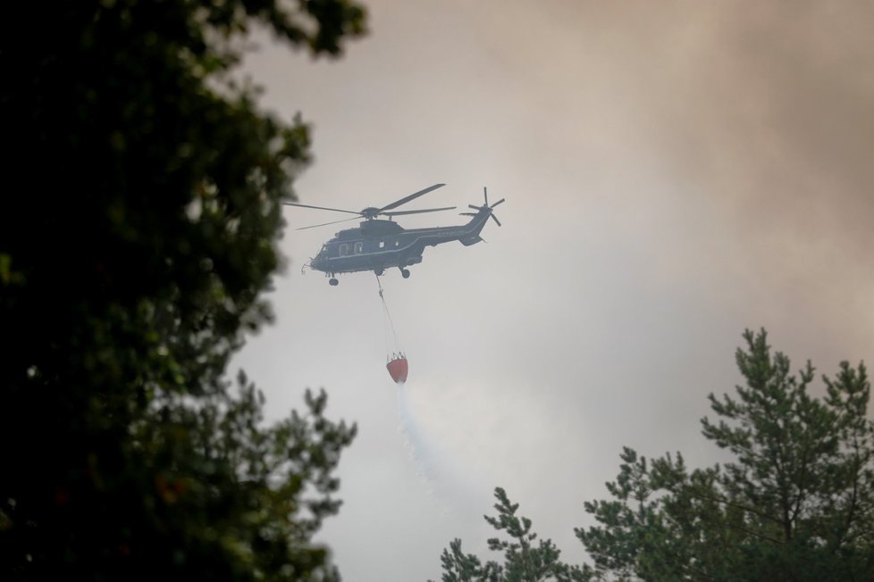 V boji s plameny pomáhá hasičům i vrtulník (24.8.2018).
