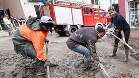 Při uklízení následků povodní v Německu pomáhají i uprchlíci.