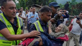 Záchranáři odnášejí oběť bleskové povodně do bezpečí podél řeky Trishuli v nepálském okrese Nuwakot. (27.8.2026)