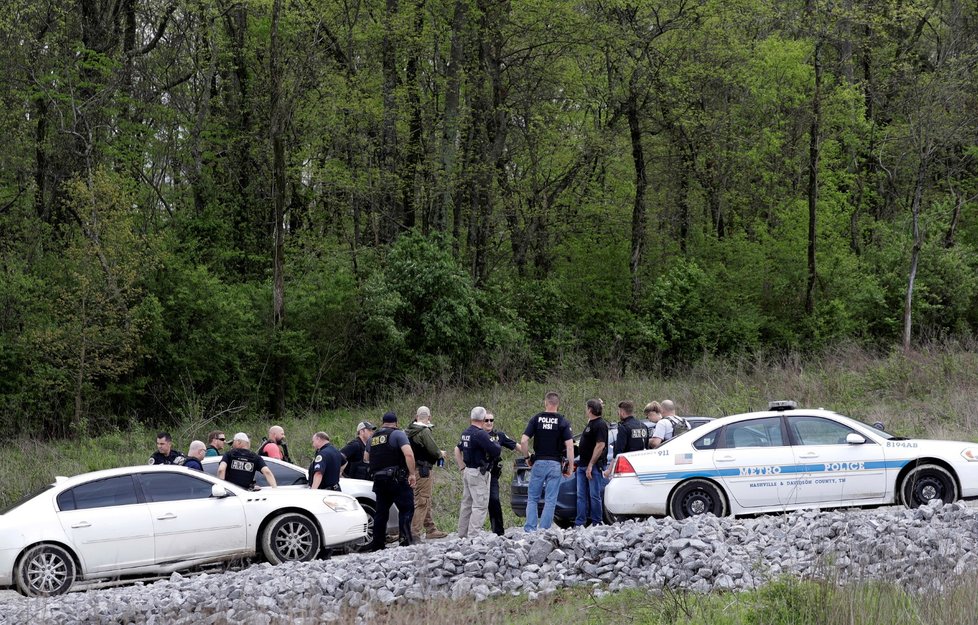 policie shromážděná podél lesa na místě, kde byl dopaden střelec
