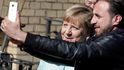 Neznámý uprchlík se v táboře fotí s německou kancléřkou Angelou Merkelovou