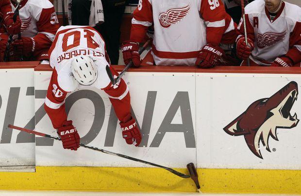 Henrik Zetterberg se pomocí hokejky natahuje na láhev piva, kterou někdo z fanoušků vhodil na plochu. Henrik Zetterberg se pomocí hokejky natahuje na láhev piva, kterou někdo z fanoušků vhodil na plochu.