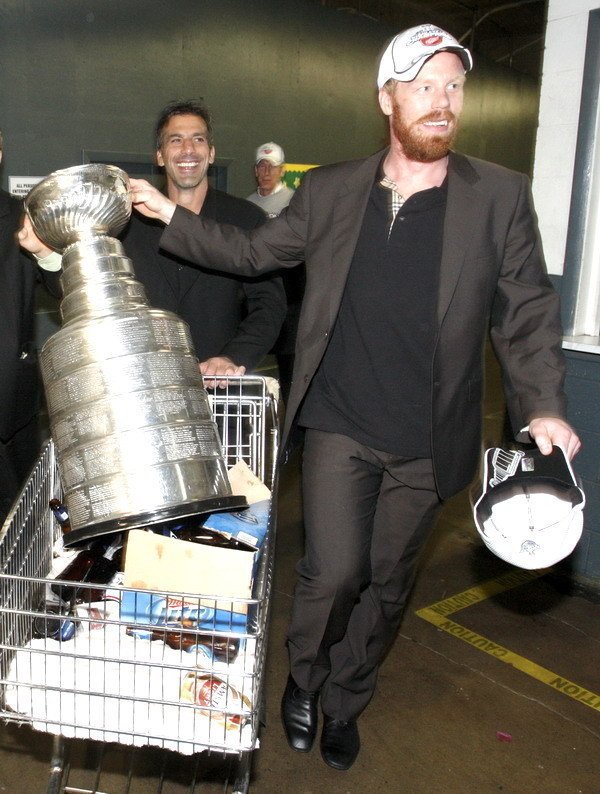 Hráči Detroitu Red Wings&#39; Chris Chelios (vľavo) a Švéd Johan Franzen prevážajú trofej do autobusu.