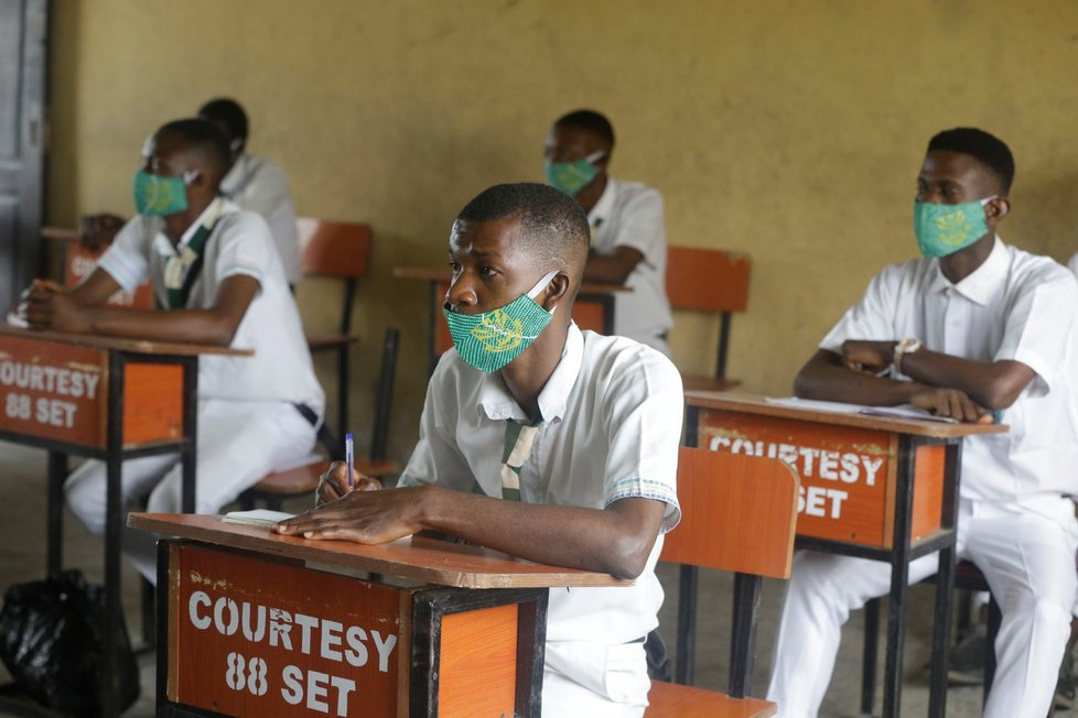 Před vstupem do školy v Nigérii změří učitelé studentům teplotu. Vstup do budovy je možný jen v rouškách. Na jejich povinné nošení upozorňují také cedule
