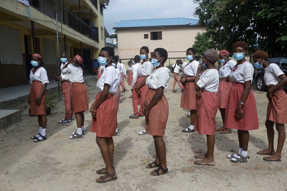 Před vstupem do školy v Nigérii změří učitelé studentům teplotu. Vstup do budovy je možný jen v rouškách. Na jejich povinné nošení upozorňují také cedule