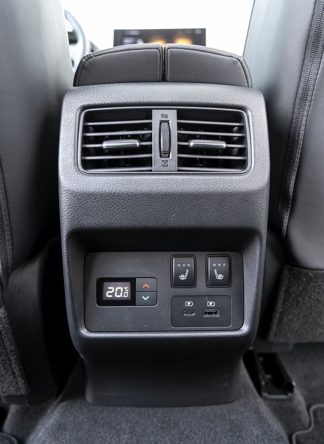 Nissan soustředil do loketní opěrky jak výdechy ventilace, tak porty USB (1x USB-A a 1x USB-C) a ovládání výhřevu sedadel. Má i třetí zónu klimatizace.