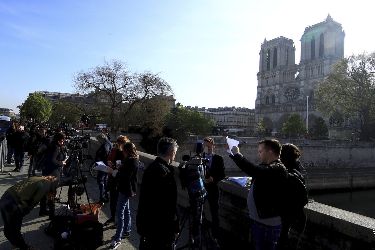 U katedrály Notre-Dame se stále scházejí davy, budovu hlídají hasiči a policisté, (17.04.2019).