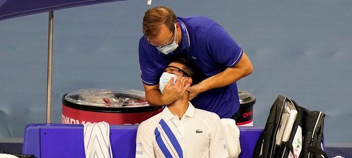 Novak Djokovič si nechává namasírovat bolavý krk během utkání druhého kola tenisového turnaje v New Yorku
