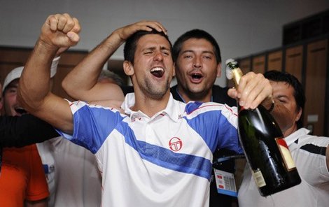 Novak Djokovič slaví šampaňským triumf na Australian Open.
