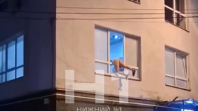 Spoře oděná prostitutka visící z okna v Novgorodu