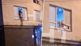 Spoře oděná prostitutka visící z okna v Novgorodu