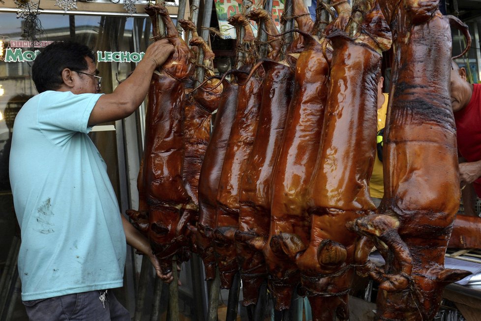 Prodejce na Filipínách připravuje pro zákazníky pečená prasátka