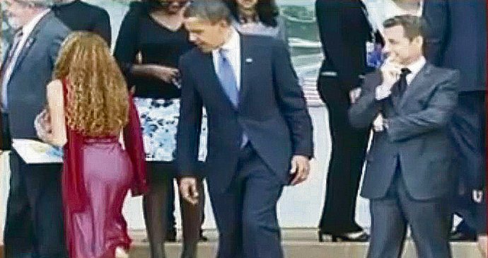Barack Obama a Nicolas Sarkozy si zálibně prohlížejí pozadí ženy, která se s nimi jde fotit