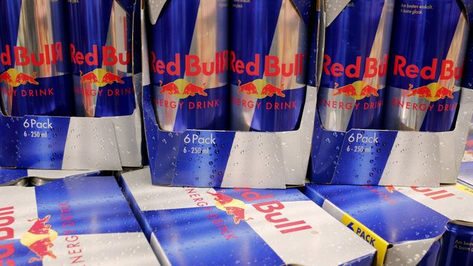 Plechovky energy drinku Red Bull v regálu švýcarského obchodu