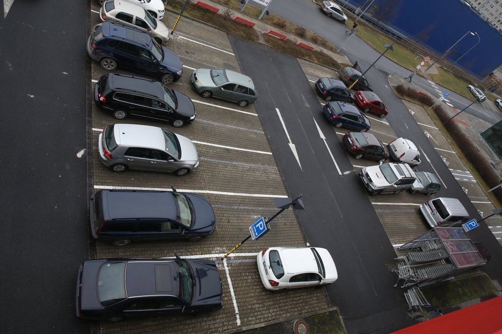 Parkoviště u obchodního centra na Černém Mostě 23. 12. odpoledne.