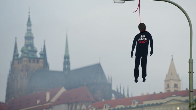 Pět figurín oběšenců s červenou oprátkou kolem krku a nápisem Šel proti KSČ(M) na hrudi visí od dnešních 05:00 na lampách v Praze na Klárově.