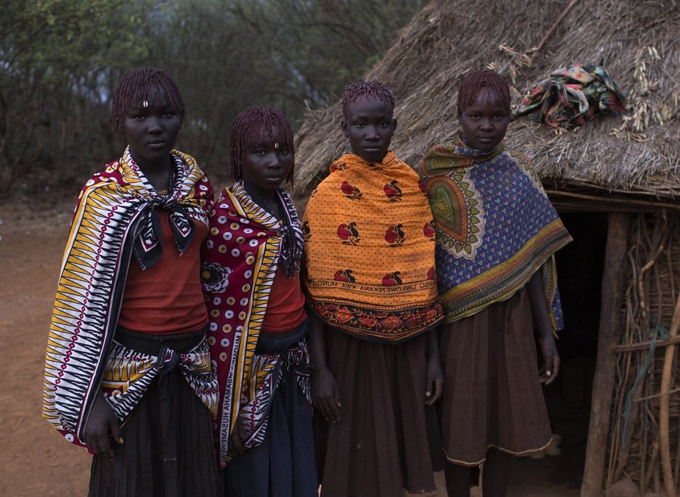 Čtyři dívky z kmene Pokot stojí před domem jedné z nich jen pár okamžiků před začátkem krvavého rituálu