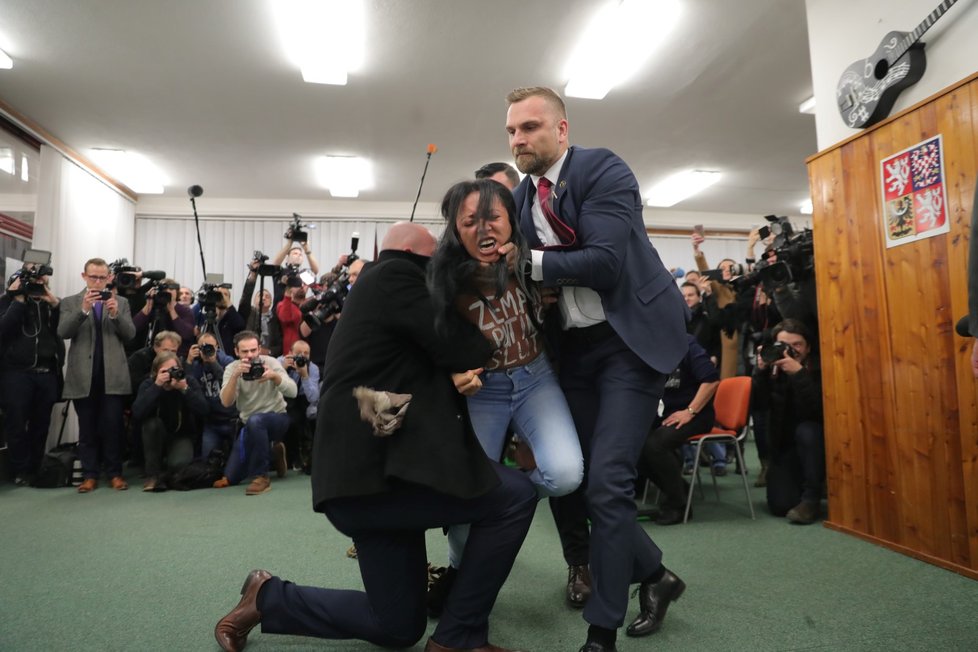 Zemanova ochranka v akci během prezidentských voleb. Na prezidenta vystartovala polonahá aktivistka