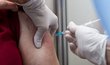 Zdravotní sestra očkuje ženu vakcínou proti koronaviru v očkovacím centru v budově Fakulty jaderné a fyzikálně inženýrské ČVUT v Děčíně.
