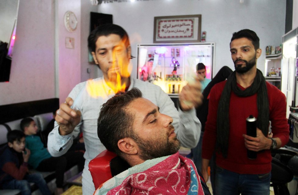 Ramadan Edwan, palestinský kadeřník podnikající v pásmu Gazy, upravuje odvážným lidem vlasy za pomoci ohně.