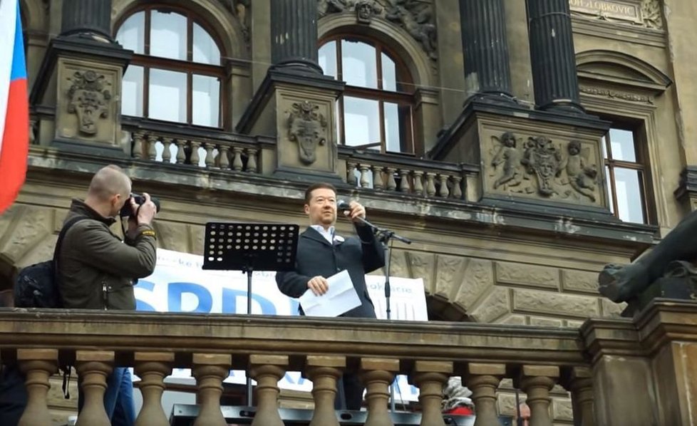 Okamura si postěžoval, že mu během projevu scházel stojan na mikrofon, proto pak - stejně jako Brichta - mával jen jednou rukou