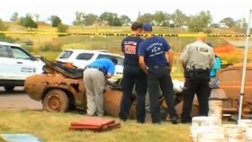 Policisté prohledávají jeden z vytažených vozů, ve kterých nalezli kostlivce