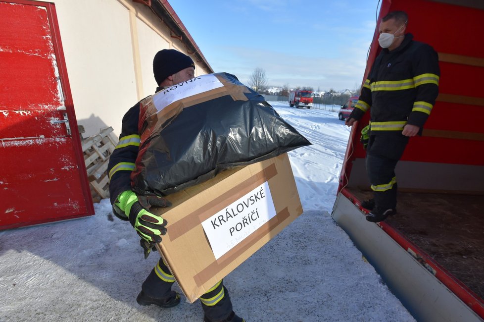 Hasiči rozdělovali a rozváželi ze skladu v Karlových Varech ochranné roušky do okresů Sokolov a Cheb, kde se rychle šíří covid-19 (13. 2. 2021).