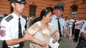 Justiční stráž vyvádí manželku Josefa Lakatoše Helenu.