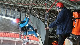 Horolezec Tomáš Lenc novinářům předvádí, jak se dá slaňovat ze střechy pavilonu Z.