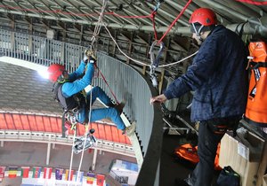 Horolezec Tomáš Lenc novinářům předvádí, jak se dá slaňovat ze střechy pavilonu Z.