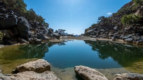 Jezero vedle jeskyně v pohoří Jebel Sham, známém jako Grand Canyon Ománu