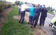 Tři ho podpírali Cestou k policejnímu autu ho podpírali tři muži.