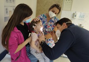 Lékař Lukáš Homola vyšetřuje Melánii (4) z ukrajinské Irpině. Na klíně ji drží její máma Xenia.